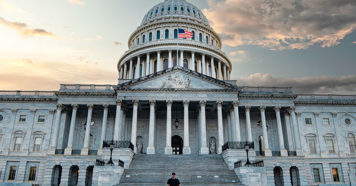 Front view of the iconic United States Capitol with dramatic evening sky.