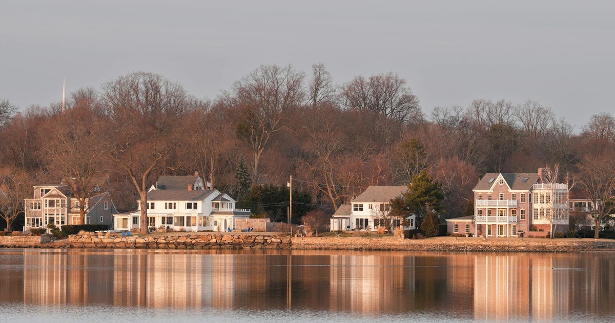 Beautiful waterfront homes in Stamford, Connecticut at twilight reflecting over calm water.