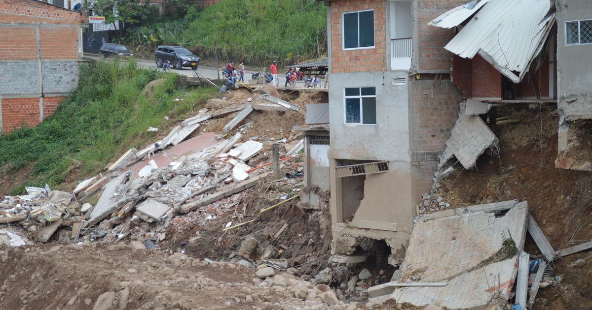 A residential building partially collapsed due to a natural disaster, showcasing severe structural damage.