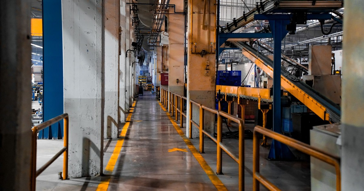Wide view of a modern factory interior showcasing industrial machinery and conveyor systems.