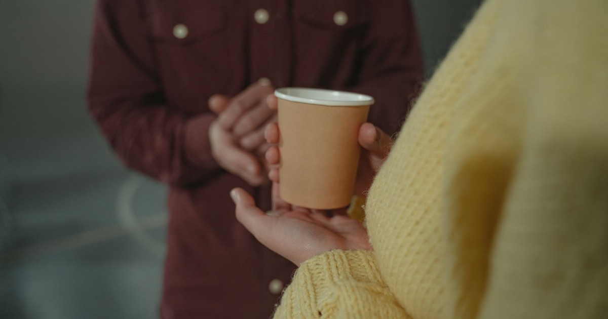 Hands holding a disposable cup, highlighting personal connection.