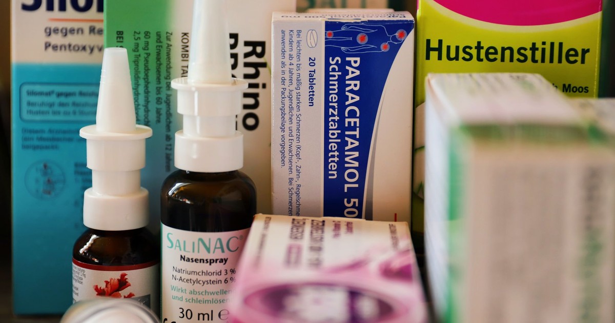 Assortment of cold and flu medications on a pharmacy counter.