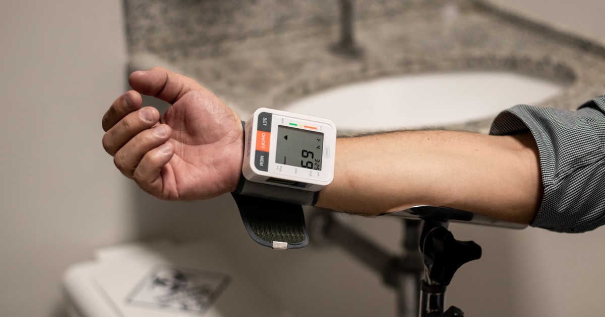 Close-up of an arm using a wrist sphygmomanometer in a healthcare setting.