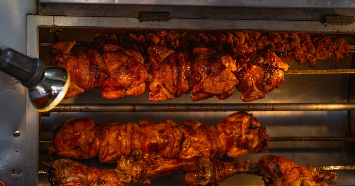 Mouth-watering rotisserie chickens cooking at a street food stall in Ciudad de México, perfect for cuisine lovers.