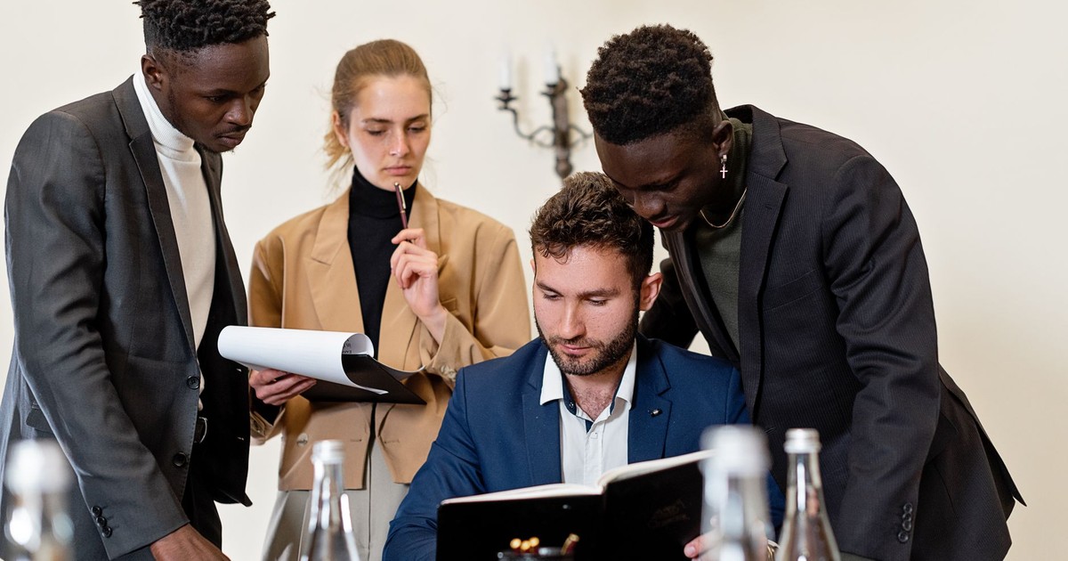 A diverse team of professionals collaborating around a table in a modern office setting.