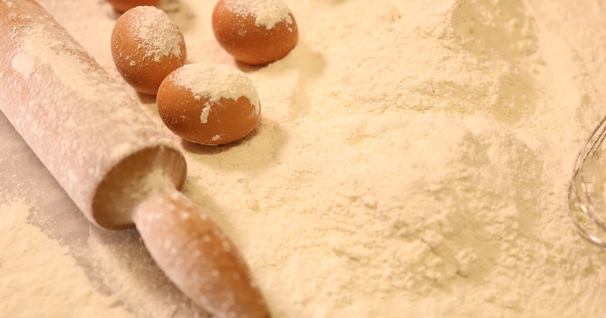 Close-up of baking ingredients including eggs, flour, and a rolling pin.