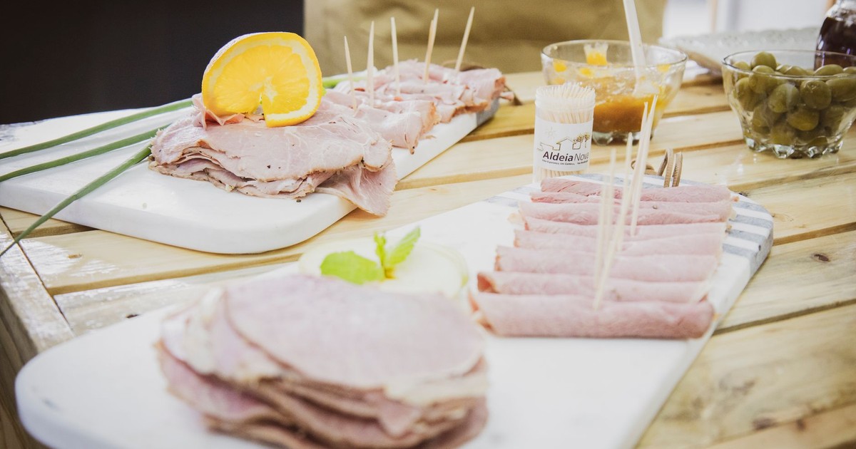 Delicious sliced ham appetizers, garnished with orange and served on wooden trays.