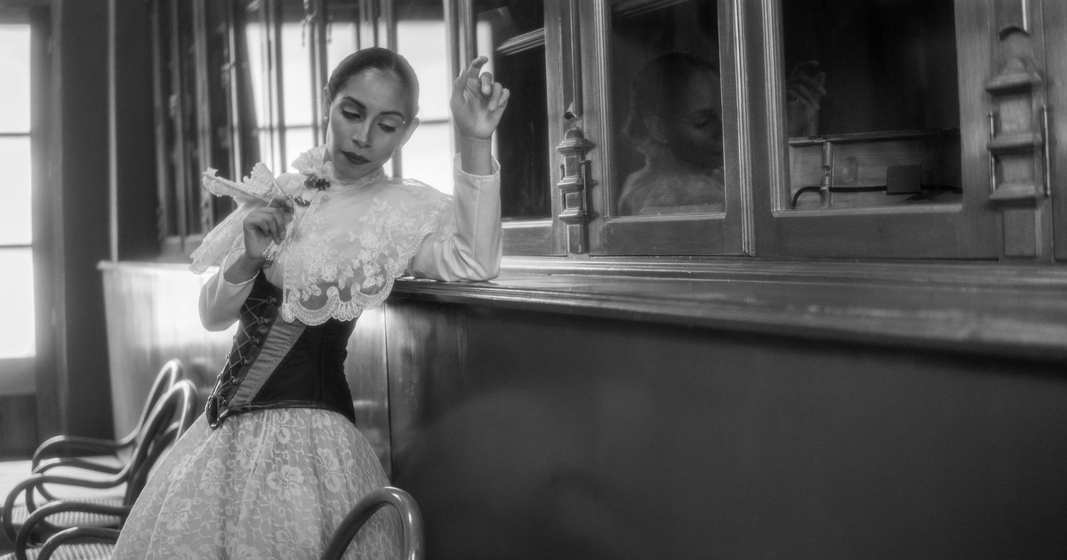 A woman in Mexico City poses in elegant traditional clothing, captured in black and white.