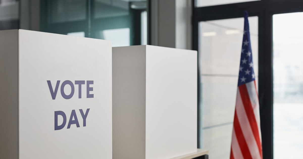 Voting booth setup with American flag, symbolizing election day.