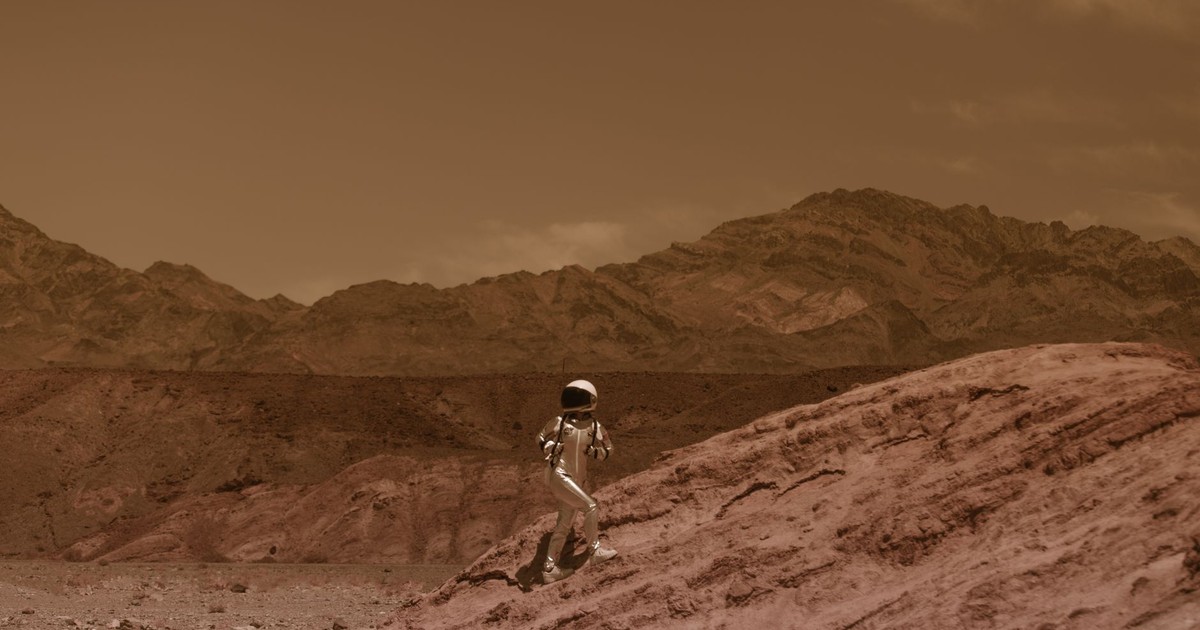 Astronaut walking on a barren landscape resembling Mars, with futuristic and adventurous vibes.