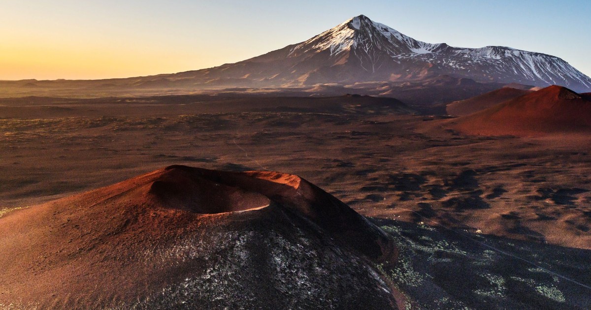 Stunning view of volcanoes at sunset on the Kamchatka Peninsula, showcasing natural beauty.
