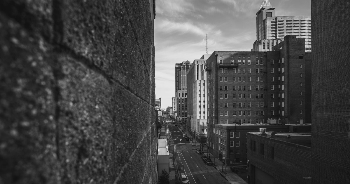 A captivating black and white street view of downtown Raleigh, NC, showcasing urban architecture and an empty road.