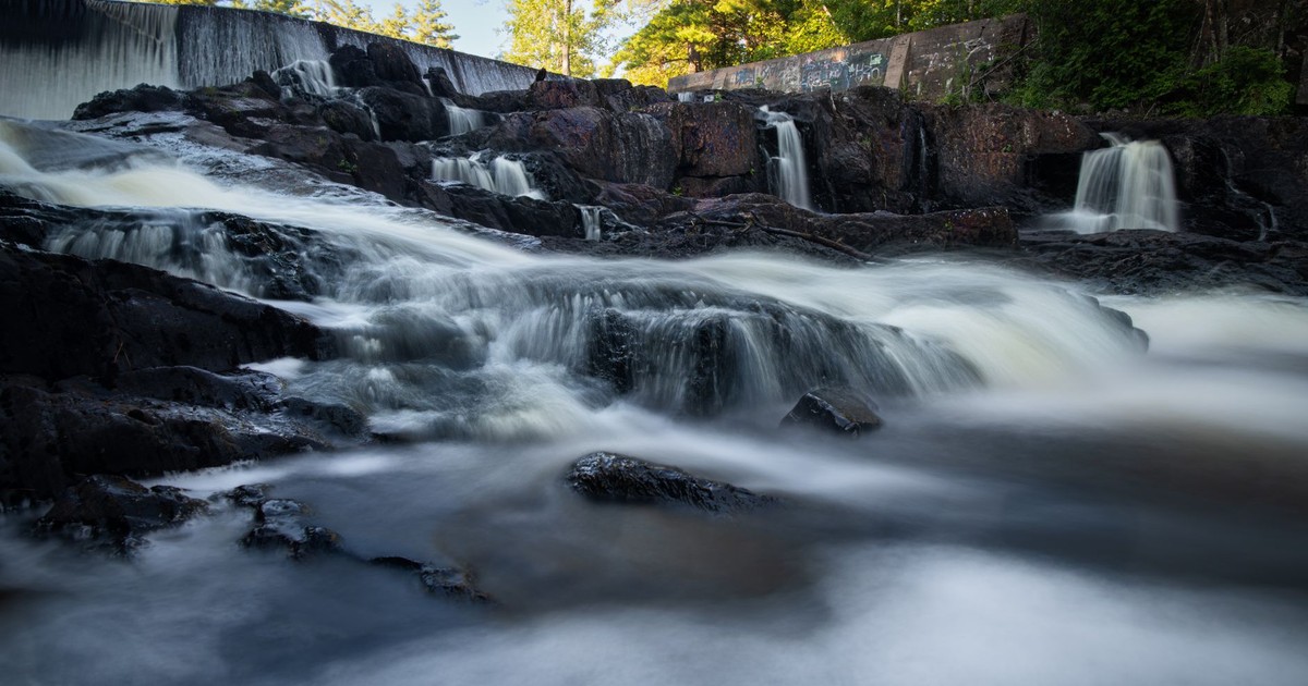 Beautiful waterfall cascading over rocks in a serene forest setting.