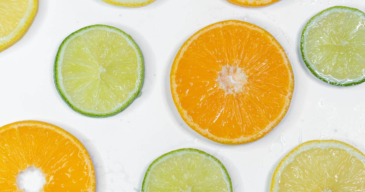 Colorful citrus slices including orange, lemon, and lime on a white background.