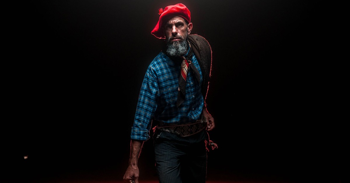 Portrait of a gaucho in traditional attire, illuminated by dramatic lighting.