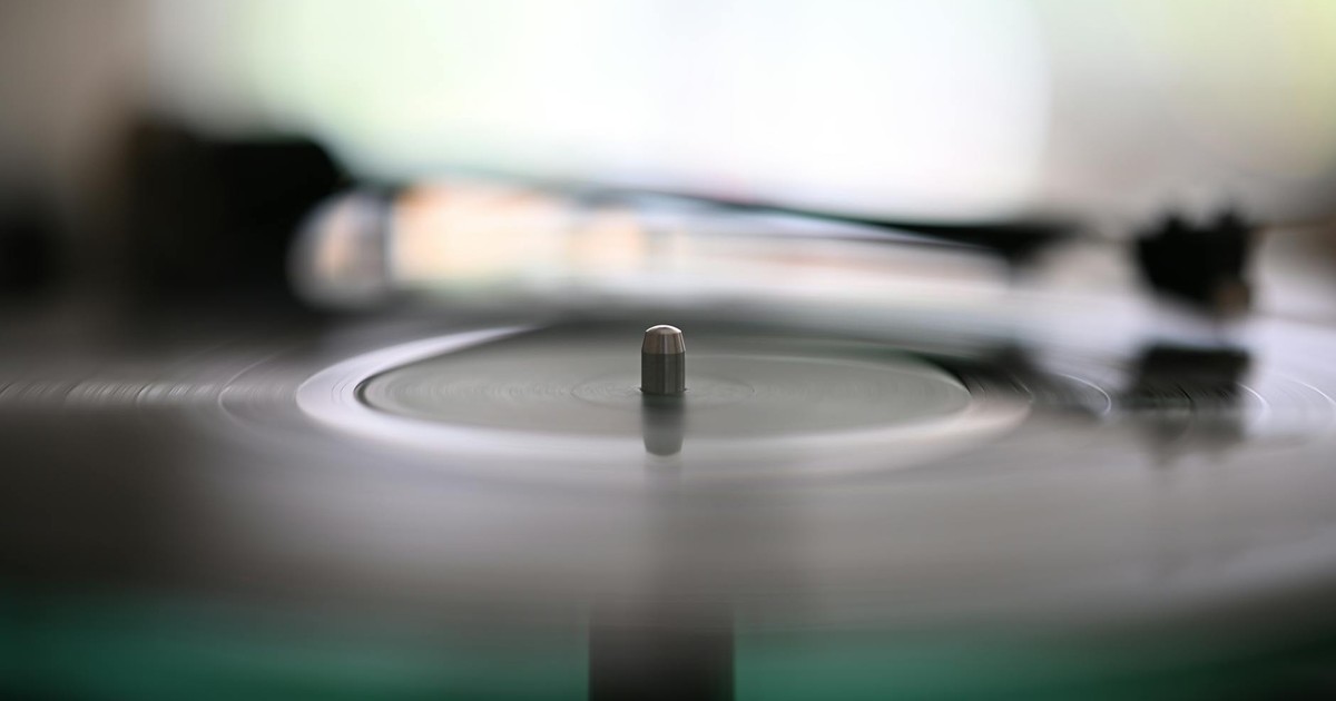 Blurry spinning vinyl record with needle on turntable, capturing the essence of analog music.