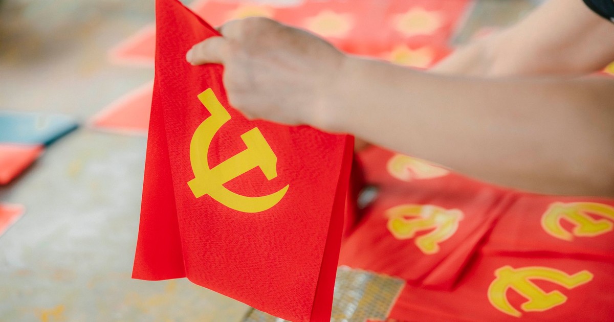 A person creating multiple Soviet Union flags in an indoor setting.