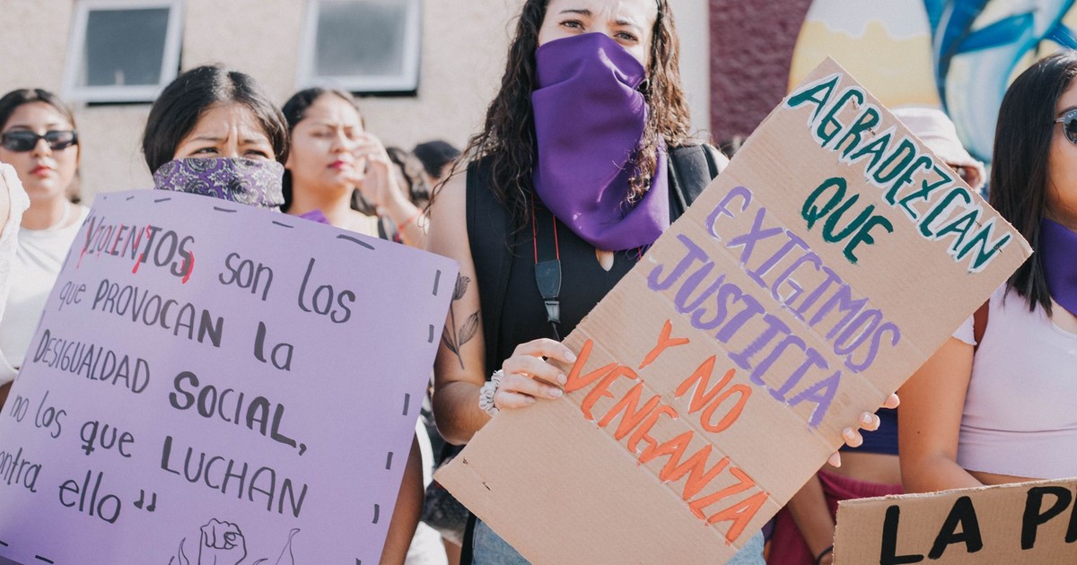 A group of women at a protest holding signs advocating for social equality and justice.