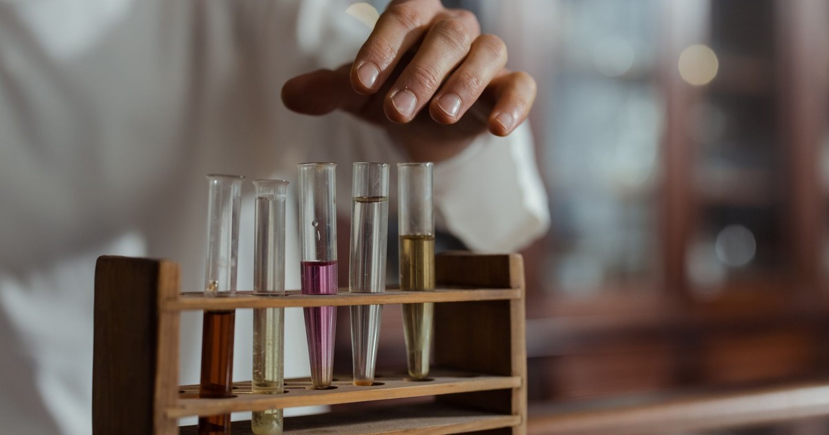 Close-up of a hand handling test tubes in a laboratory showcasing scientific research.