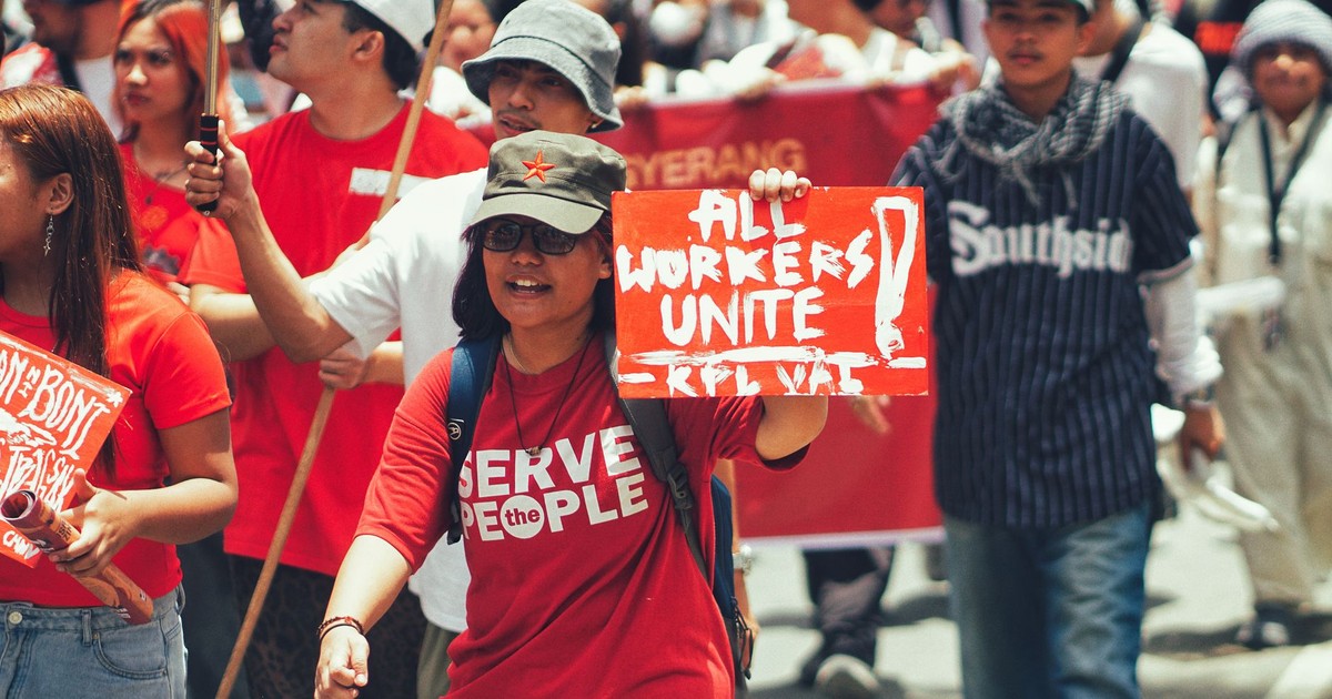 Crowd of diverse protesters during a workers' rights demonstration in the city.