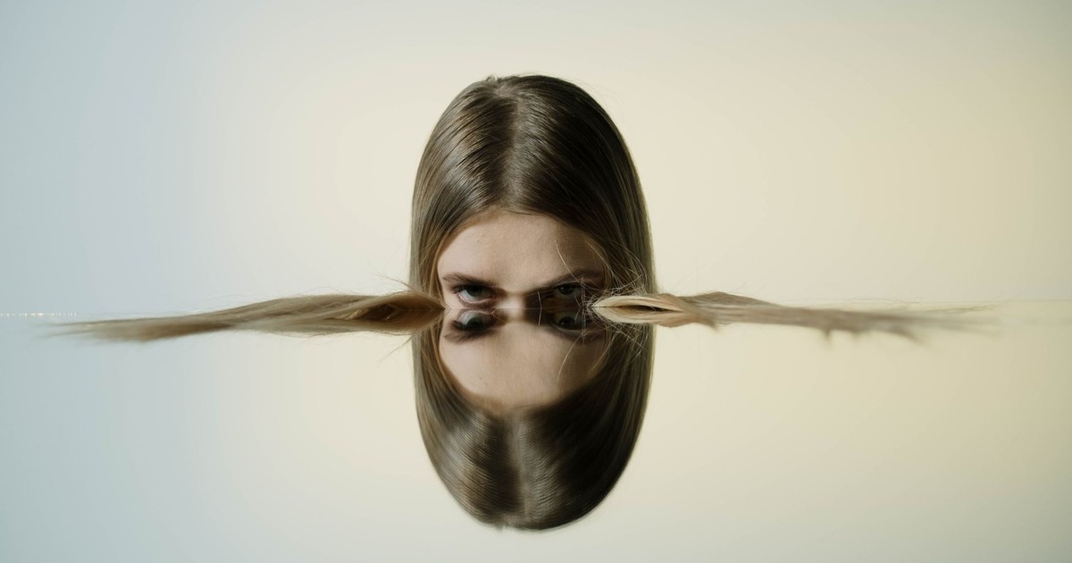 A conceptual portrait of a woman's reflection in water, offering tranquil and artistic vibes.