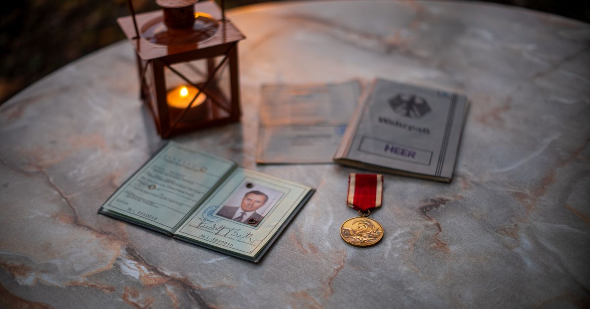 A collection of vintage military memorabilia with a glowing lantern on a stone table.