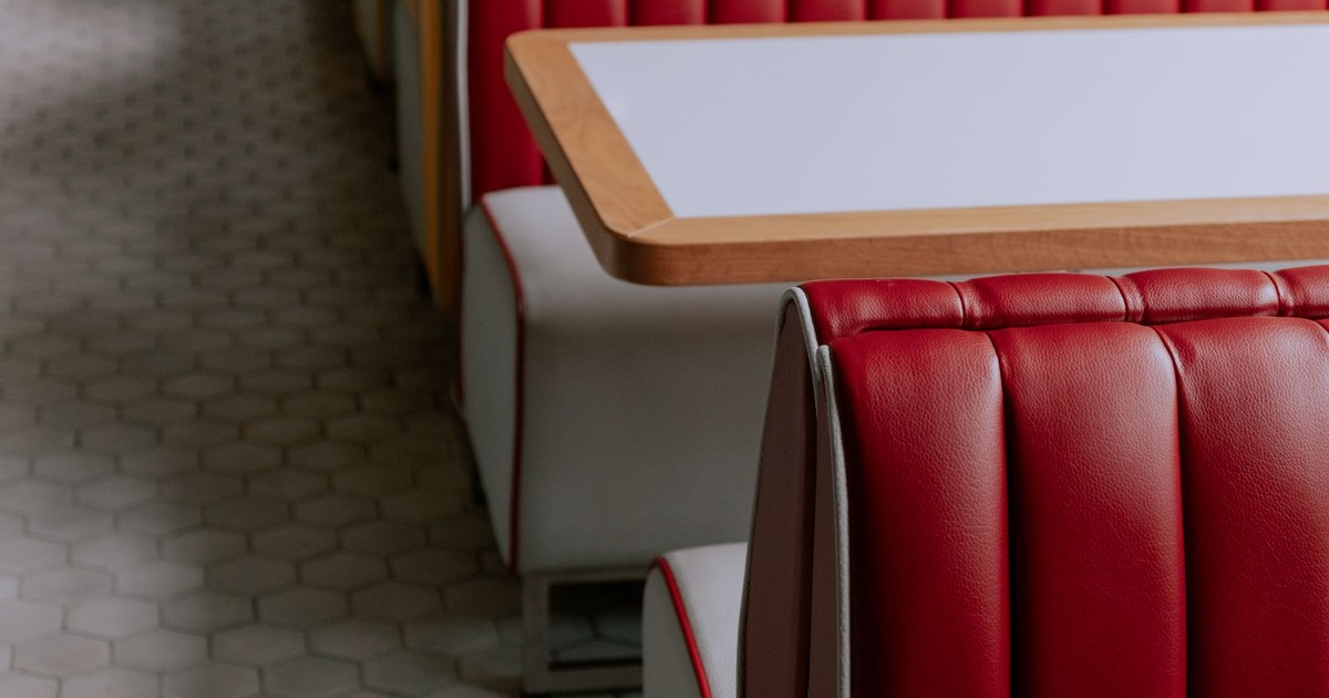Stylish red leather booth seating in a minimalist cafe setting, perfect for modern dining.