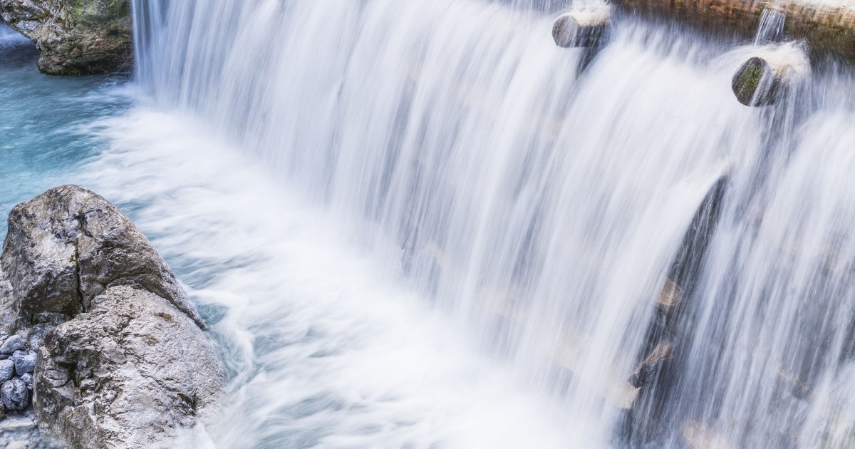 Tranquil waterfall flowing over rocks, creating a serene and picturesque scene in nature.