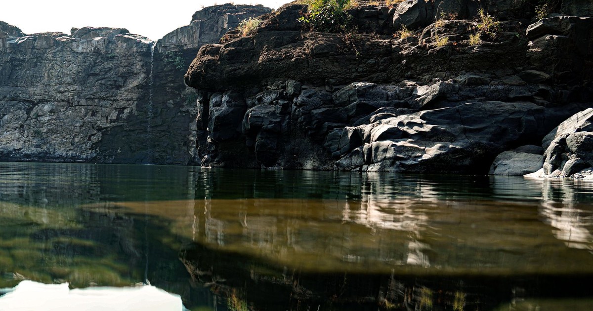 Peaceful lake reflecting majestic rock formations and cliffs, perfect for nature photography.