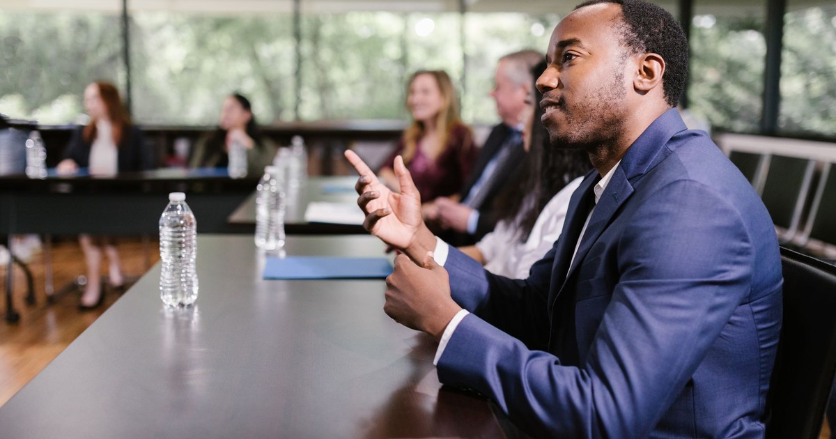 Professionals in a conference room engaged in discussion, showcasing diversity and teamwork.
