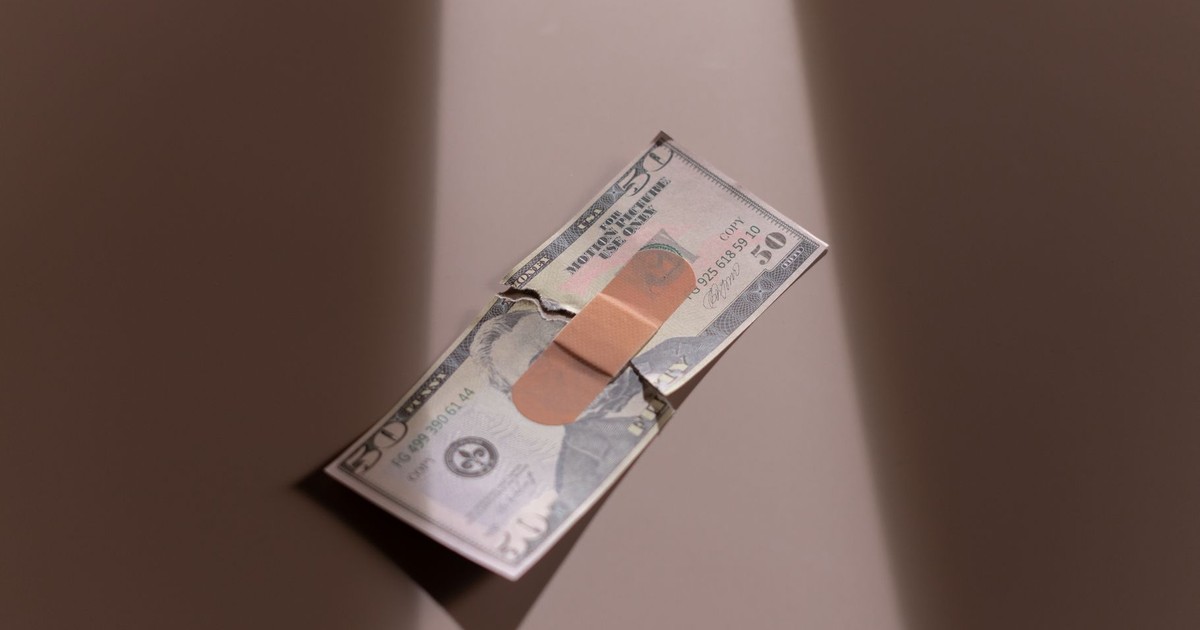 A $50 bill with a bandage symbolizes financial recovery and repair.