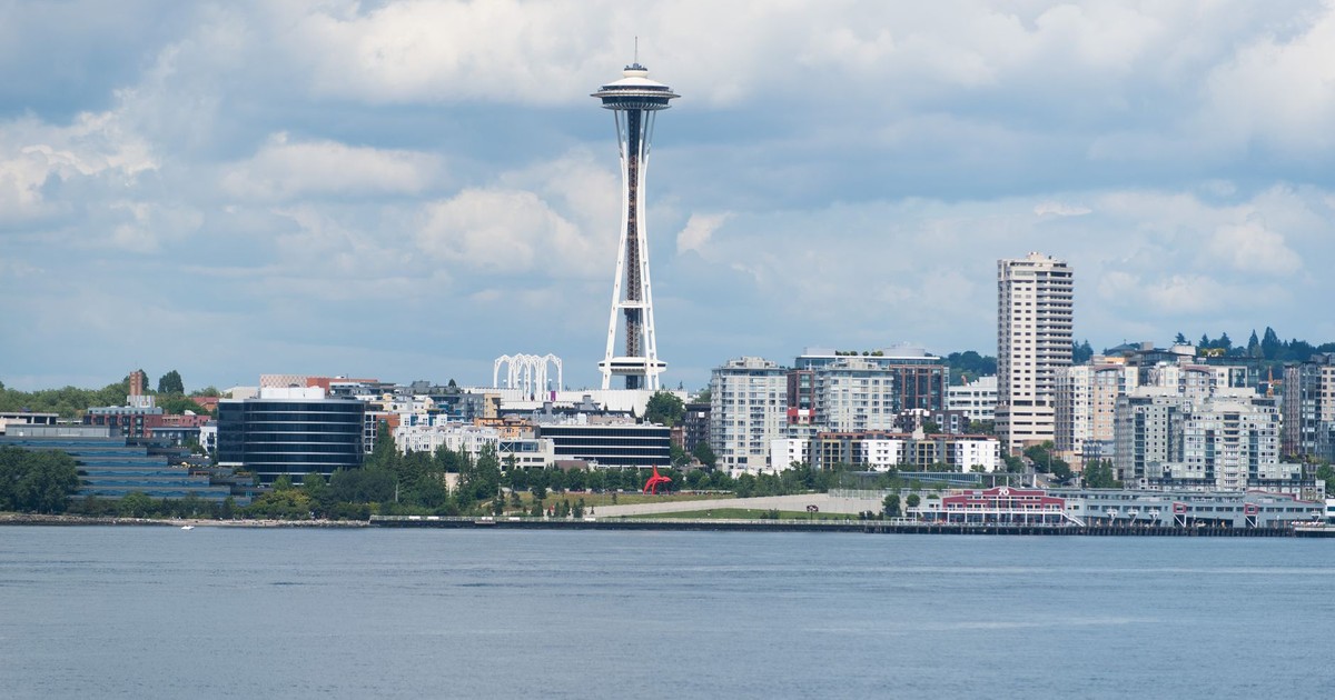 A scenic view of the Seattle skyline featuring the iconic Space Needle against a cloudy sky.