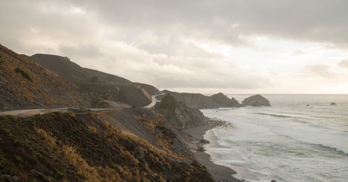 Captivating view of California's rugged coastline with waves crashing against the cliffside.
