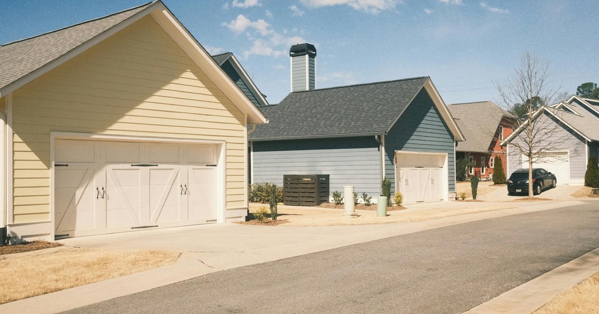A serene suburban street in Athens, GA showcasing modern garages under a clear sky.