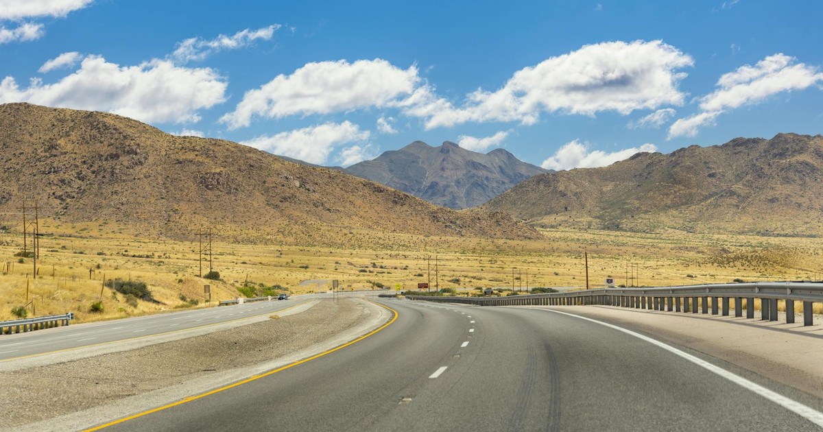 Explore the picturesque highway winding through the mountains in El Paso, Texas, under a vibrant sky.