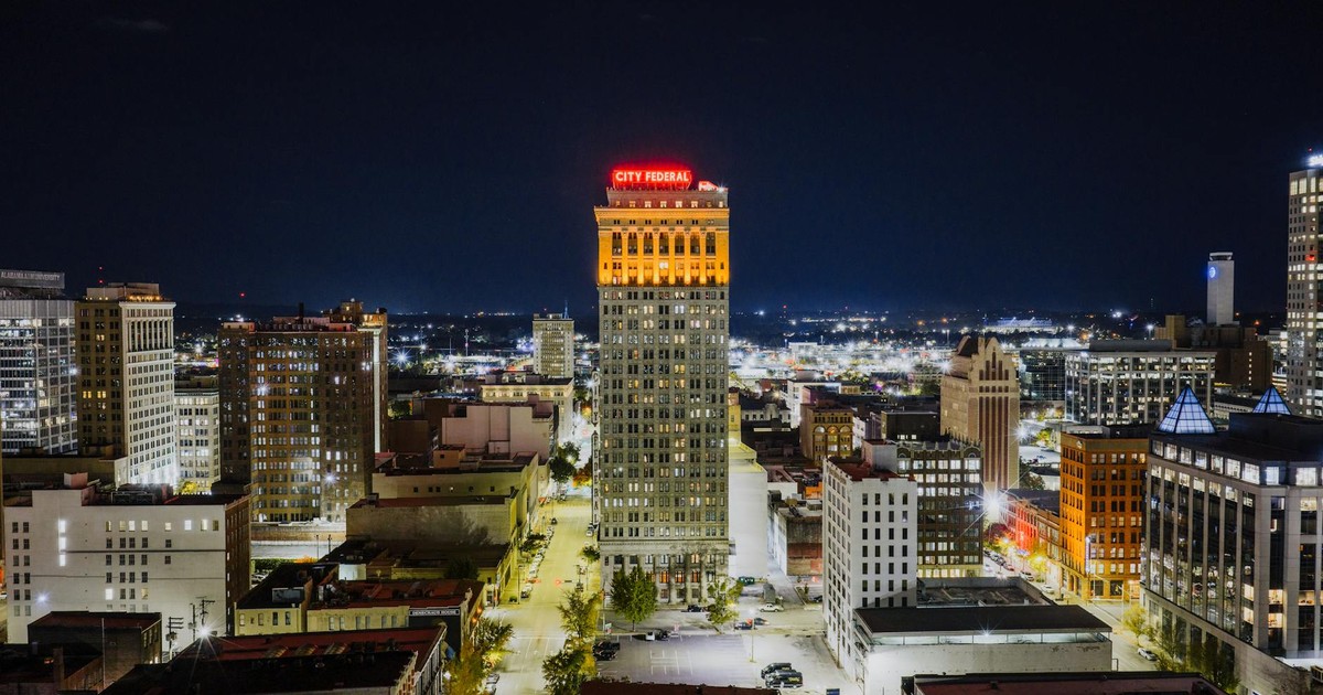 Aerial view of Birmingham's City Federal Building illuminated at night, showcasing urban architecture.
