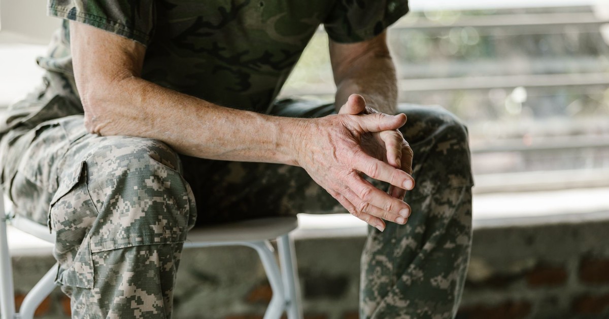 Close-up of a military veteran's hands in a therapy session, emphasizing mental health support.