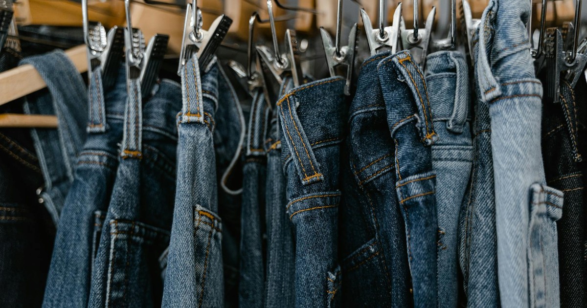 Close-up of various denim jeans hanging on a rack, perfect for fashion and retail themes.