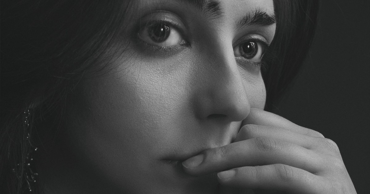 Close-up black-and-white portrait of a woman with thoughtful expression.