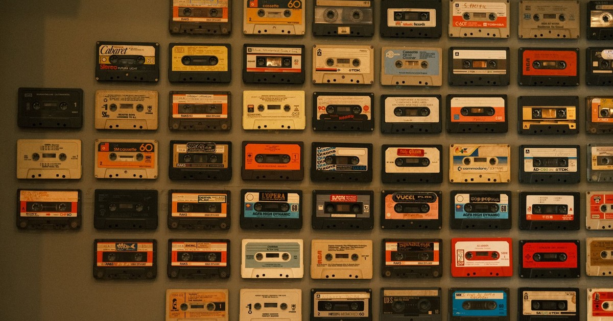 A colorful display of vintage cassette tapes arranged on a wall, evoking retro music nostalgia.