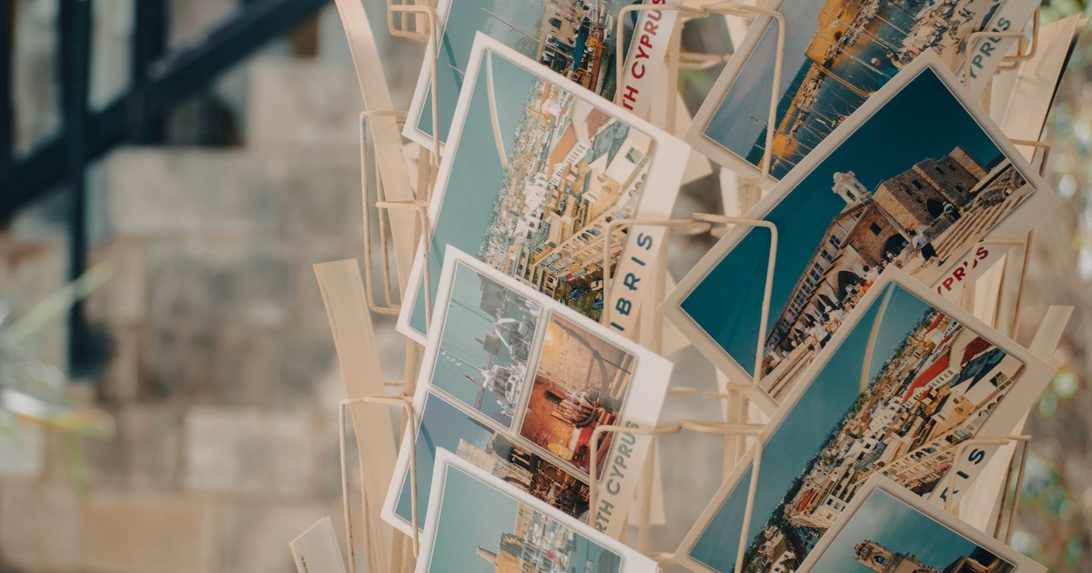 Rack of vibrant Cyprus postcards showcasing scenic views and landmarks.