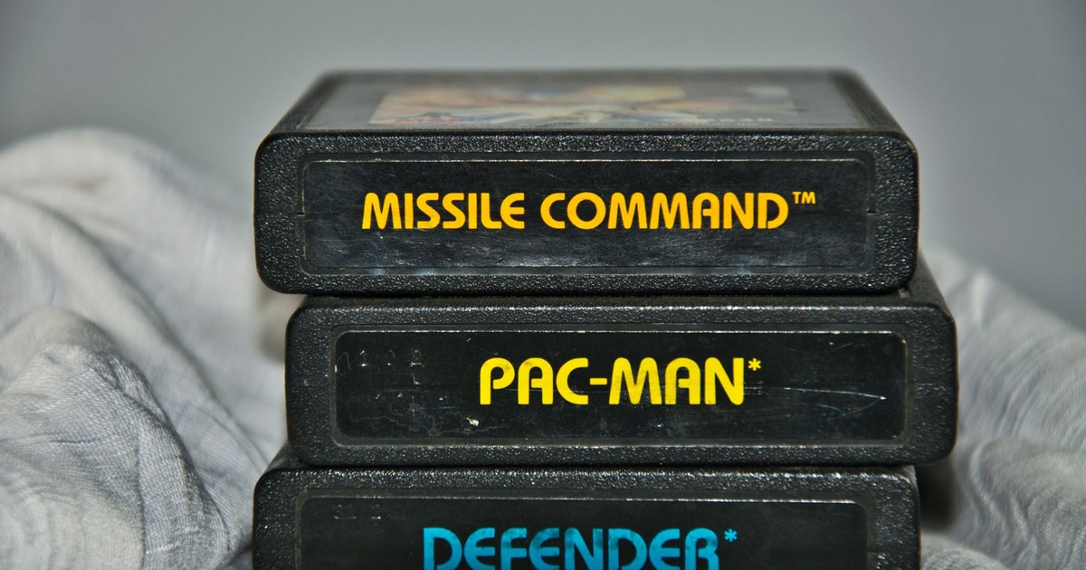 Close-up of vintage Atari game cartridges for Missile Command, Pac-Man, and Defender.