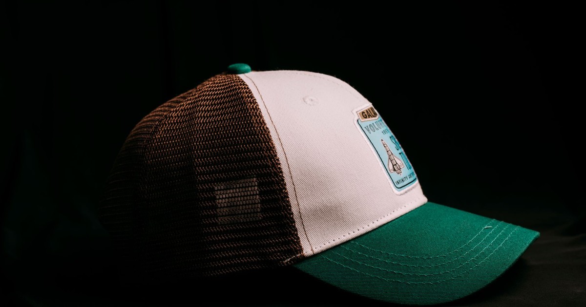 Trendy green and brown trucker hat with patch, highlight on classic design and style.