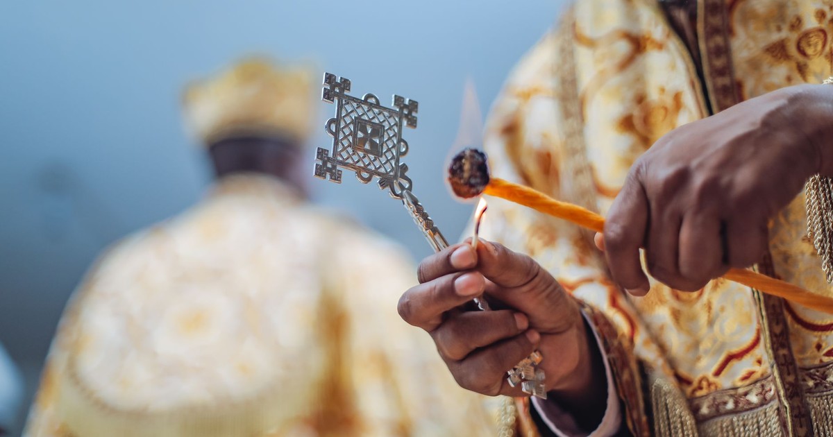 A detailed view of an Ethiopian Orthodox priest holding a ceremonial cross during a religious ritual in Addis Ababa.