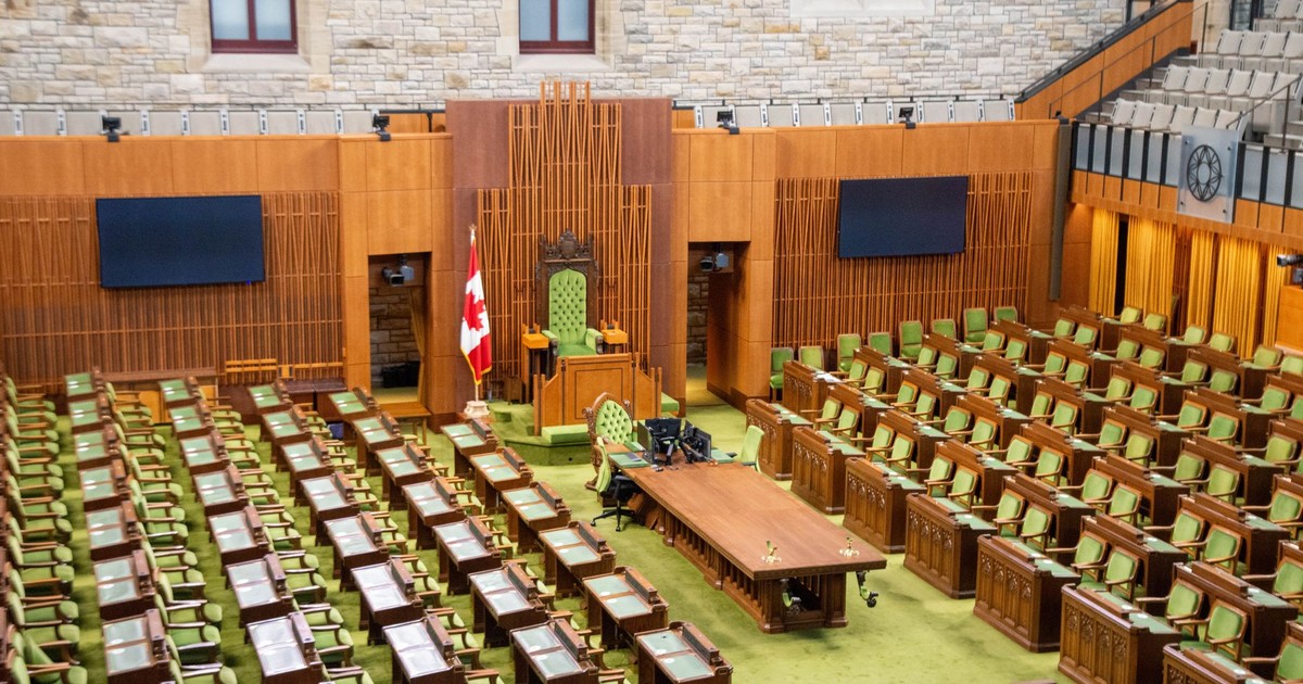 Interior view of the Canadian House of Commons with green seating and wooden decor.