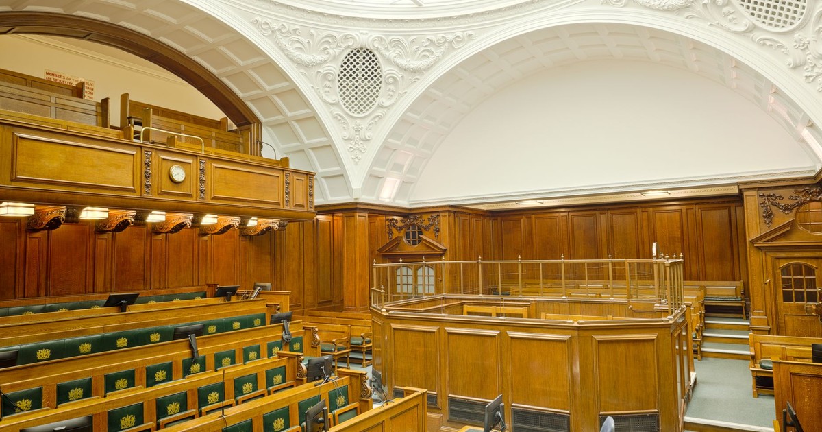 Interior view of a historic courtroom in London with ornate design and wooden furnishing.