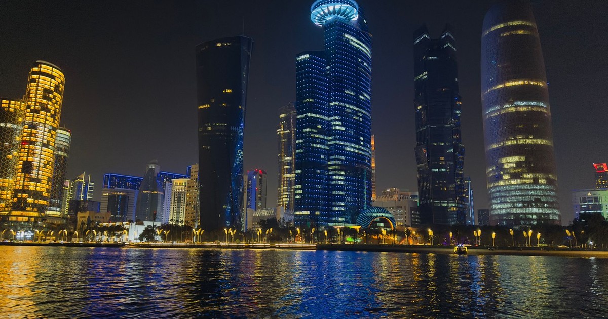 Captivating night scene of Doha's illuminated skyline reflecting on water in Qatar.