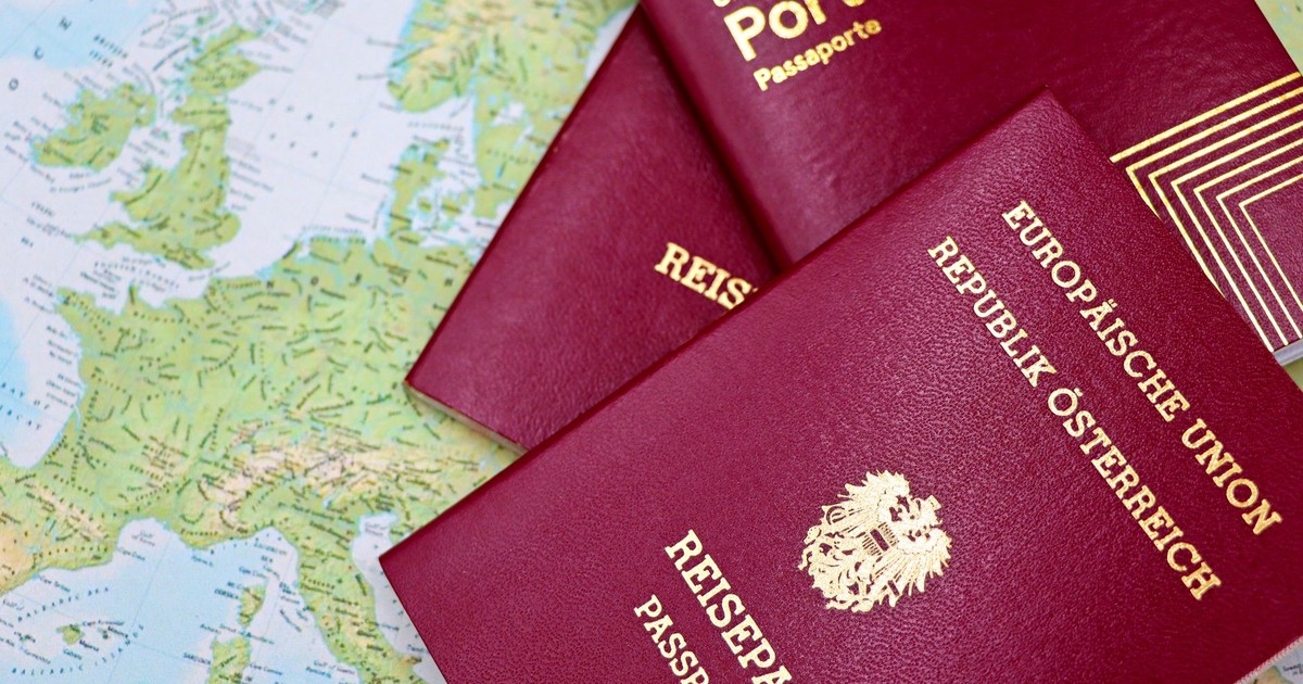 Close-up of European passports from Portugal and Austria on a world map.