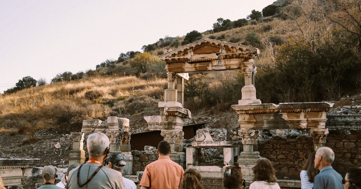 Group of tourists visiting ancient Roman ruins at Ephesus, Turkey during daytime.