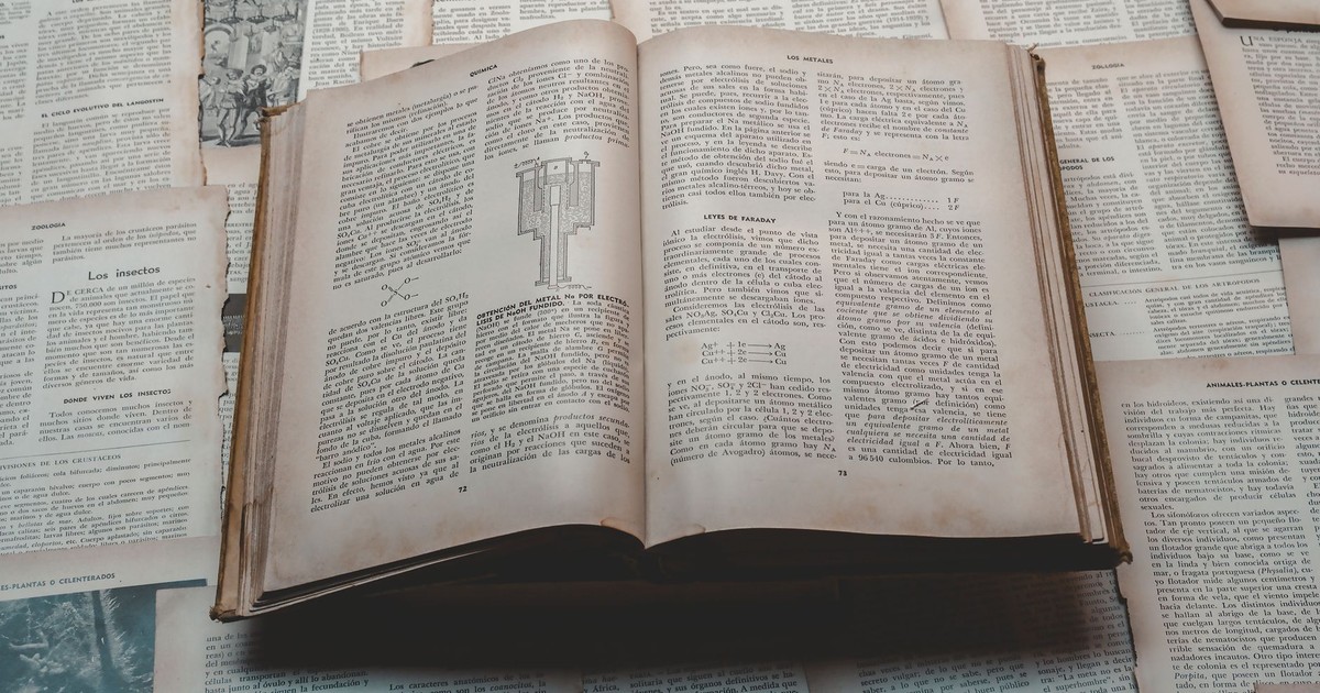 Explore a classic open book surrounded by vintage papers, perfect for historical and educational themes.